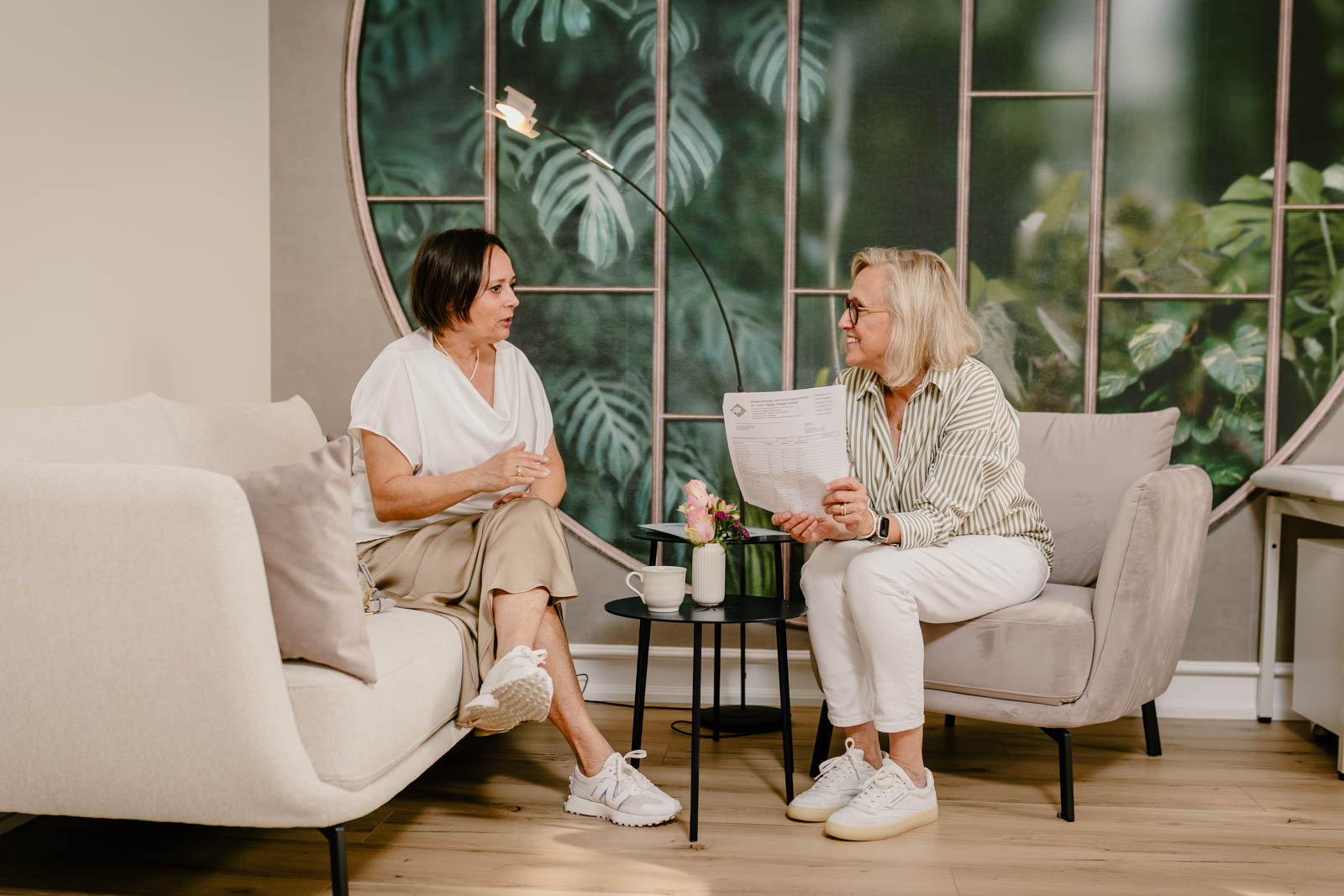 Zwei Frauen im Gespräch in einer professionellen Umgebung, aufgenommen als authentische Business-Reportage.